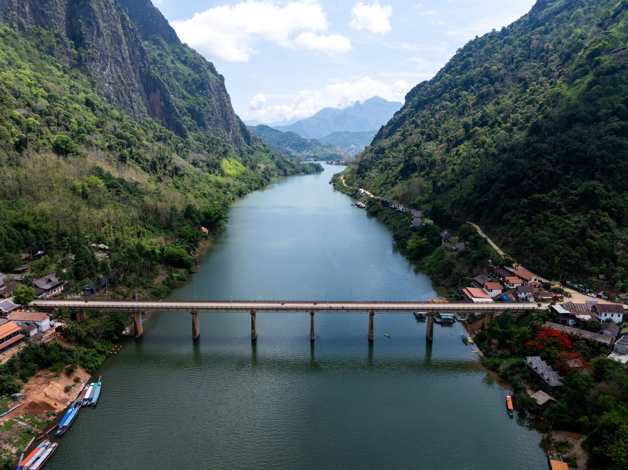 The Nam Ou river and bridge at Nong Khiaw, seen from above, between steep green mountains