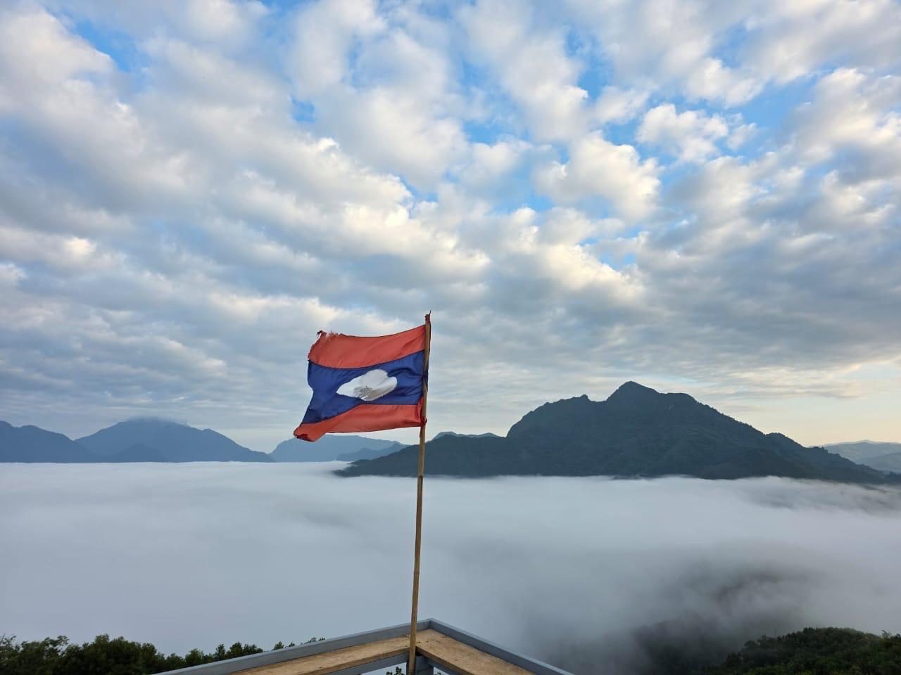 The Lao flag flying above the clouds