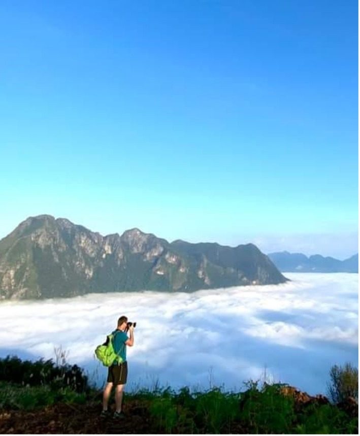A traveller photographing a sea of clouds