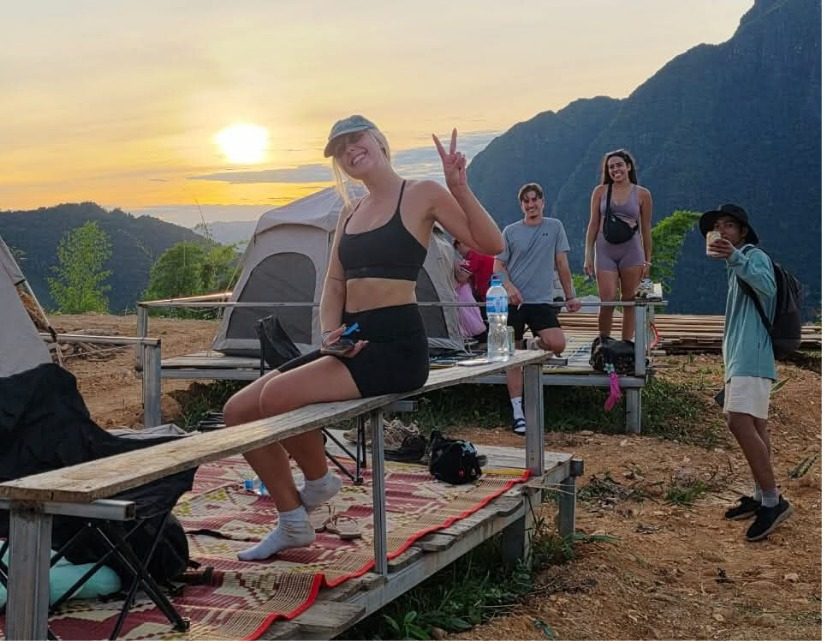 Friends relaxing at camp at golden hour