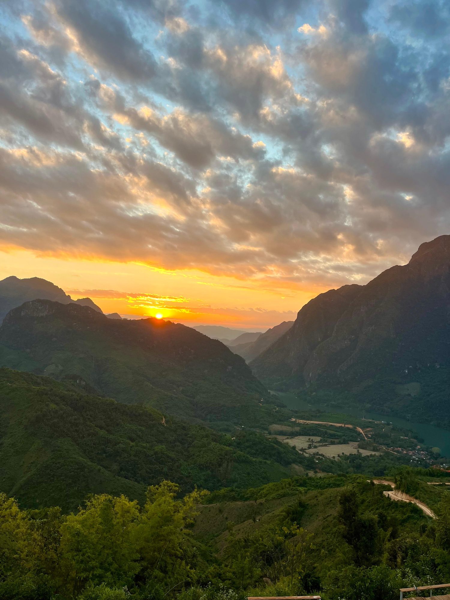 Sunset glowing over a green valley near Nong Khiaw